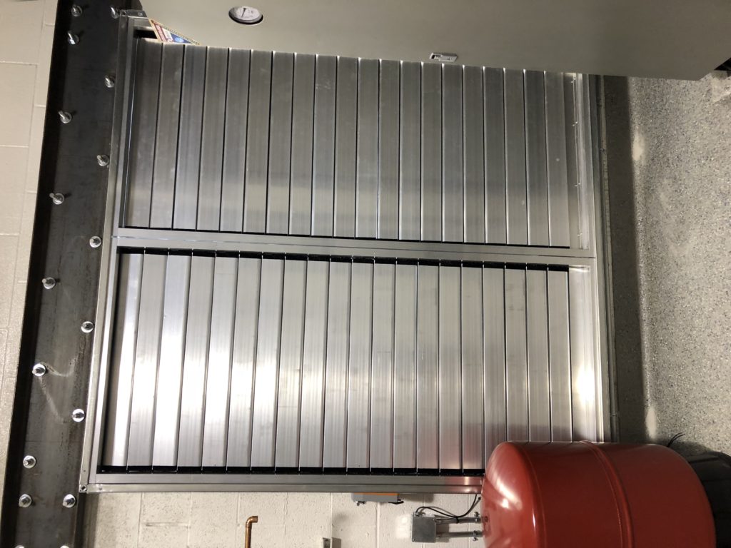 Large metallic industrial shutter door in a facility.