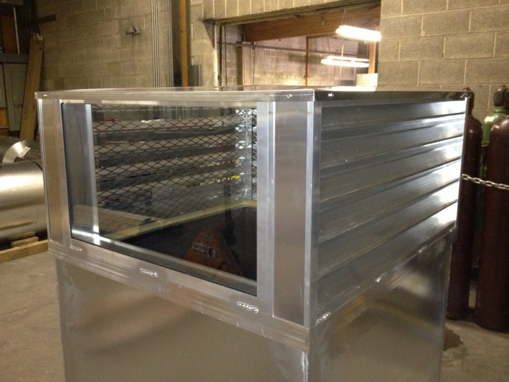 A metallic industrial ventilation duct with reflective panels.