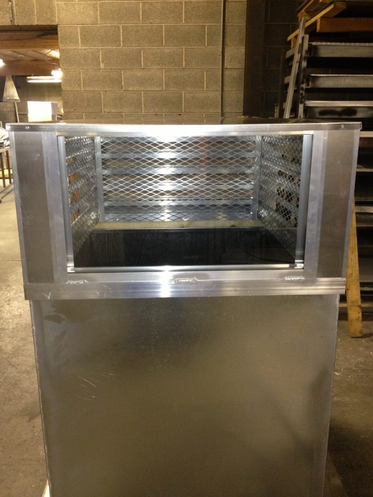 Shiny metal industrial ventilation duct with a rectangular opening.